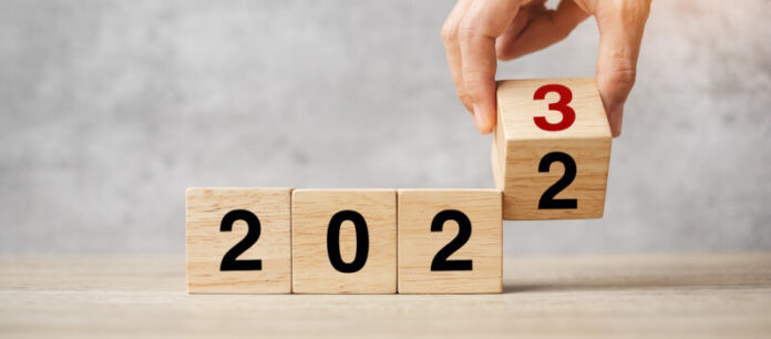 hand flipping block 2022 to 2023 text on table. Resolution, stra