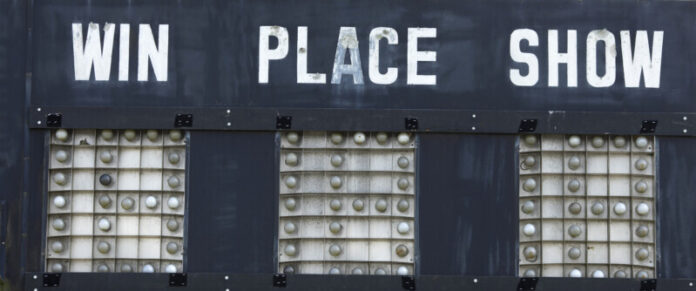 Weathered horse racing sign saying, win, place, show.
