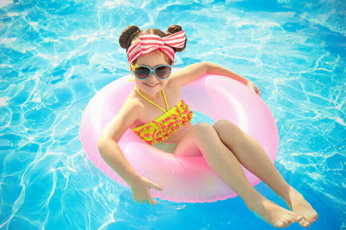 Little girl in swimming pool on sunny day