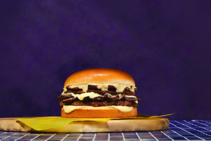 wat-24006-008-mushroomswiss-0055-0062-c-cmyk Mushroom Swiss on a yellow wrapper, cutting board in a purple environment, offered for a Limited Time