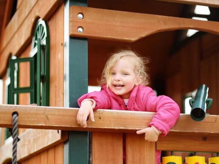 Cute little girl having fun on outdoor playground