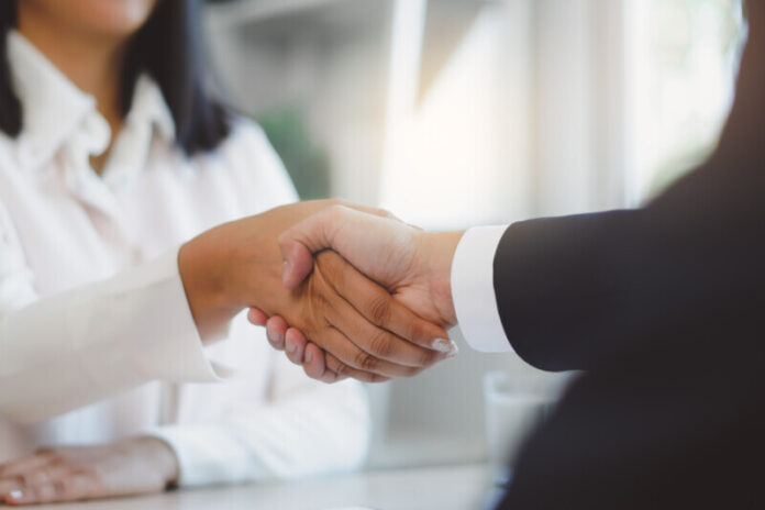 two business people shaking hands after contract is done.