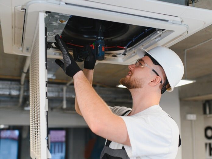 Hvac technician repairing ceiling air conditioning system The relationship between filtration efficiency and energy consumption